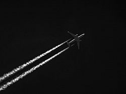 Airplane crossing a black sky