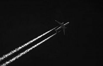 Airplane crossing a black sky