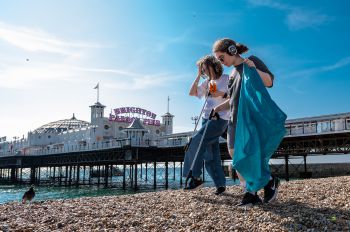 Two students on Brighton beach as part of beach clean