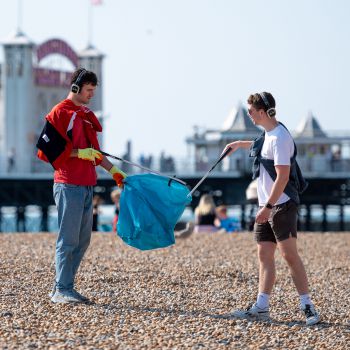 Two male students cleaning the beach