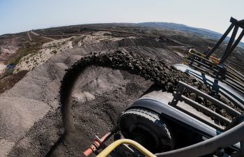 Coal goes flying off the end of a conveyor belt on a coal mining site