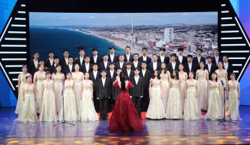 The ZJSU choir in front of an aerial view of Brighton