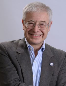 A head and shoulders photo of Professor L. Alan Winters wearing a suit and glasses