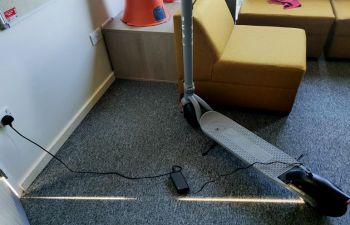 e-scooter being charged in a residence hall