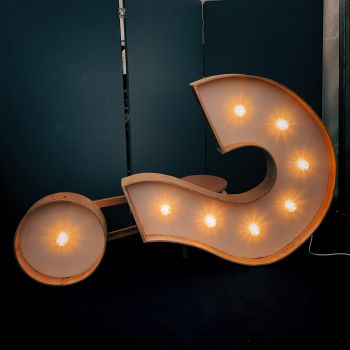 A large question mark with lights on it lies on its side