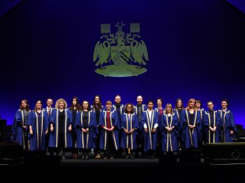 Robed figures on stage at graduation