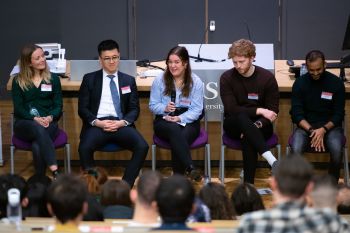 A photo of five panellists at Make it Happen 2020, sitting at the front of a lecture hall speaking to students