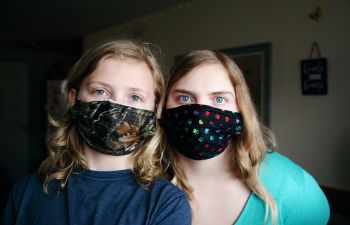 Stock photo of two people wearing colorful face coverings