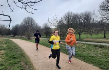 Two women running in the South Downs. One of them is wearing a Sussex yellow jersey