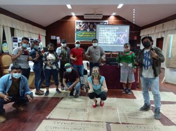 Staff and students wearijng masks posing for a picture being taken at a project workshop