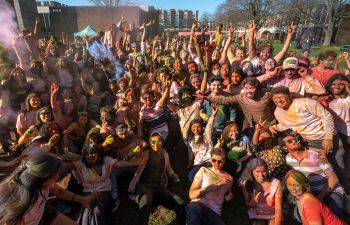 A large group of students covered in colour powder posing for the photo