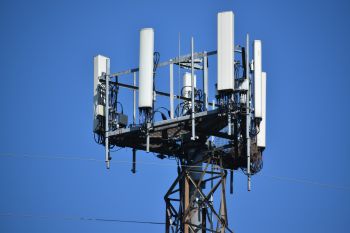 A close-up shot of the top of a large, grey 5G cell tower