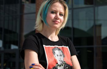 Violetta Korbina standing, arms crossed in front of the new Student Centre