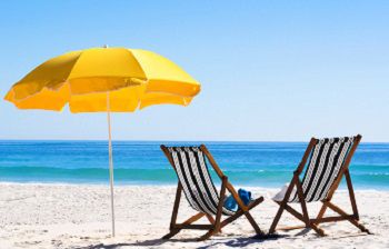 Beach with two deckchairs and a parasol