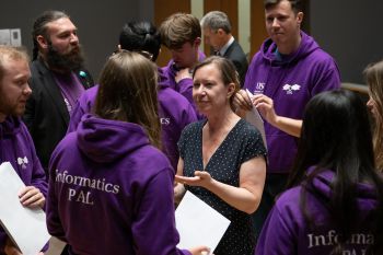 Kelly Coate chatting away with members of the Engineering and Informatics PAL team who wore their usual purple hoodies with the inscription