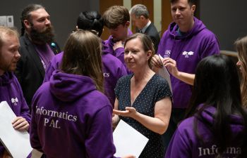 Kelly Coate chatting away with members of the Engineering and Informatics PAL team who wore their usual purple hoodies with the inscription 