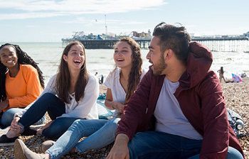 Global students sitting on Brighton beach