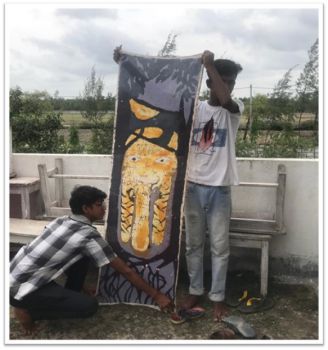 Two boys hold up a tapestry they have made