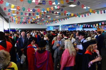 Graduates, family and staff celebrate with drinks after the Graduation ceremony