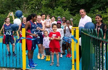 Yusuf Yusupov, young campus resident, opens new playground and basketball court with University of Sussex women's basketball team player Amani Al Zawawi