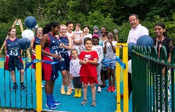 Young campus resident, Yusuf Yusupov, opens our new playground and basketball court with University of Sussex women's basketball team player Amani Al Zawawi