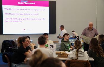 Groups of Business School students sitting in groups around a table discussing their placement year