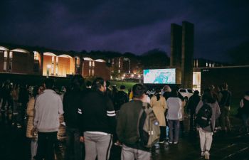 a crowd standing around screen in Sussex University Library Square