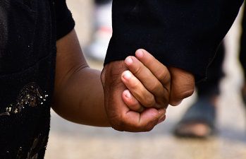 Carer and child holding hands