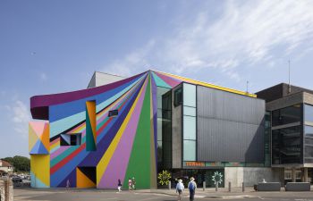 Photograph of exterior of Towner Eastbourne Gallery with some people approaching and blue sky behind