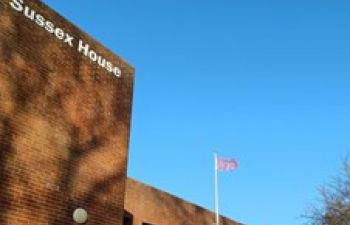 Disability flag flying over Sussex House building