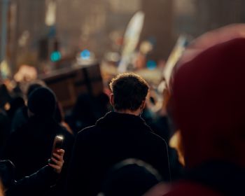 An image showing the back of a man's head in a busy crowd of people