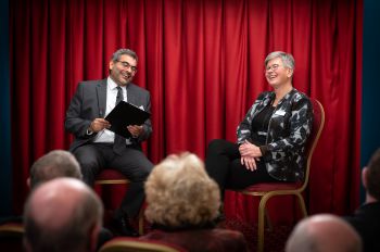 2 members of Sussex staff enjoying a conversation in front of an audience