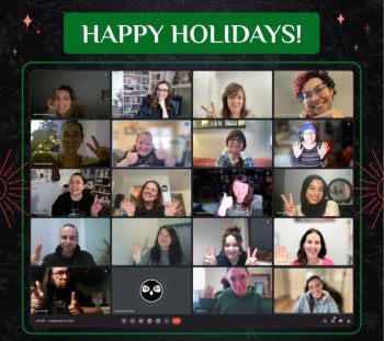 Image of a virtual Christmas party conducted on Zoom, a video conferencing platform. There are multiple employees smiling on the camera.