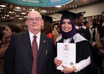 Man and female graduate standing smiling at the camera