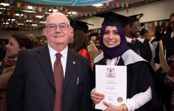 Man and female graduate standing smiling at the camera