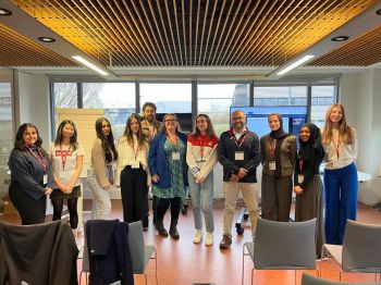 A group of Sussex students and organisers of the mentoring scheme standing in a room