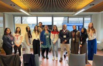 A group of Sussex students and organisers of the mentoring scheme standing in a room