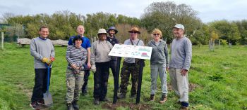 A group of volunteers and Sussex researchers installing and presenting the new pollinator signs, guides and bee hotels