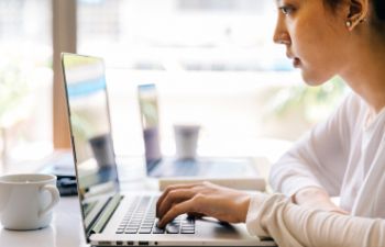 A woman reading from a laptop