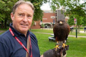 Image of falconer Gary Railton, with George the hawk perched
