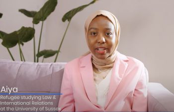 Aiya, refugee and student of Law and International Relations at Susse wearing a pink blazer and headscarf  which is nude colour