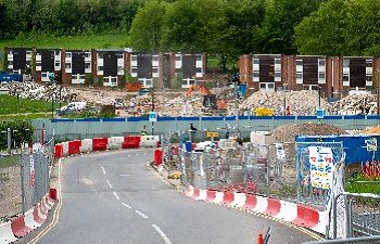 An image of old Park Village residences being demolished and a view of the temporary road.