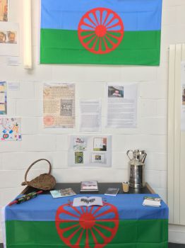 Friends, Families, and Travellers (FFT) stand during the session which includes the Gypsy, Roma and Travellers' flag