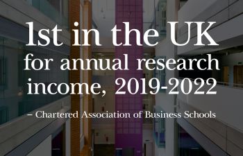 Interior of Business School with text that say 1st in UK for research income