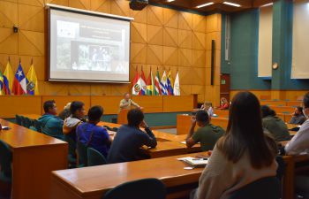 Professor Mika Peck giving a talk at in a big auditorium.