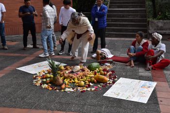 A Shaman preparing a ceremony to close the forum, with a circle of fruits on the floor.