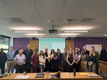Group of lecturers and students posing for group photo in Moot room