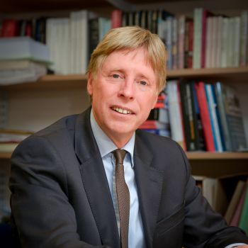Posed image of Professor Stephen Shute sitting at desk