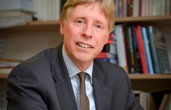 Posed image of Professor Stephen Shute sitting at desk