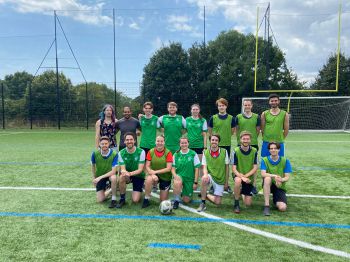 student team on the football pitch having a group photo together